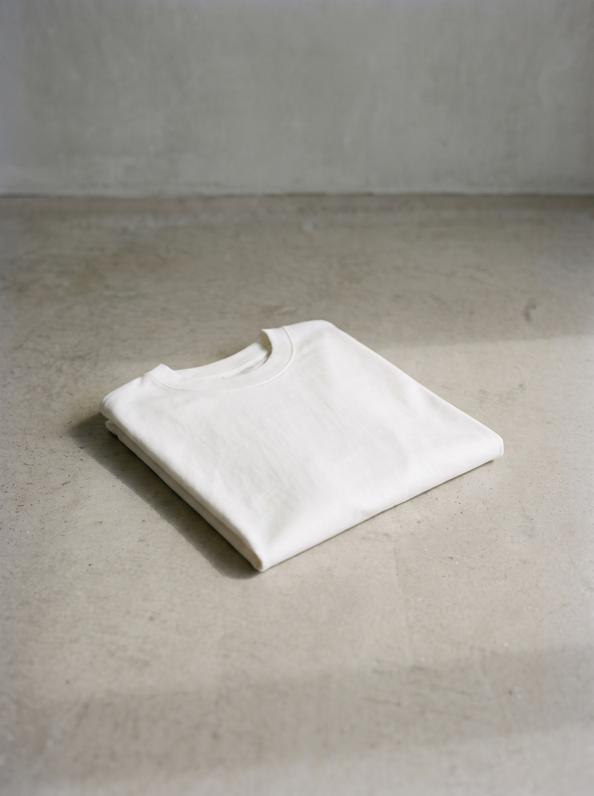 White 300GSM Heavyweight Oversized T-Shirt folded on concrete