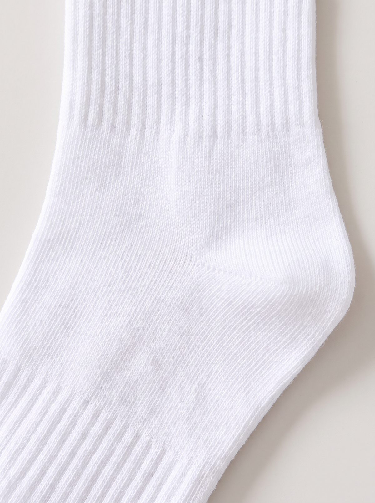 Close up of the white sports crew sock knit and ribbed cuff